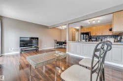 Open-concept living space featuring rich wood-finish flooring, neutral wall tones, and recessed lighting - 