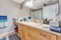 Bathroom vanity featuring a light-toned countertop, integrated sink, and wood-finish cabinetry - 