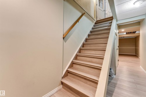 Hardwood staircase with natural wood handrail - 135 150 Edwards Drive, Edmonton, AB - Indoor Photo Showing Other Room