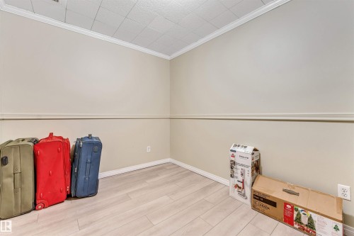 Light-toned walls with chair rail molding, crown molding, and a grid ceiling - 135 150 Edwards Drive, Edmonton, AB - Indoor Photo Showing Other Room