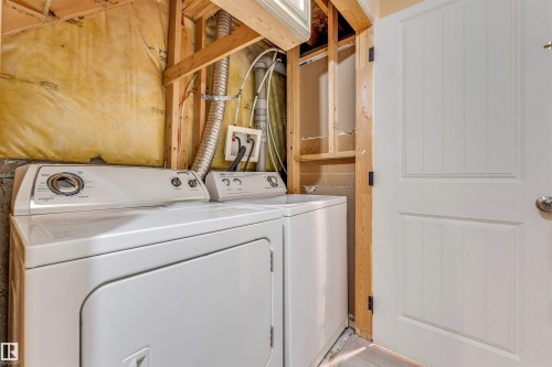 Dedicated laundry area featuring a white top-load washing machine and front-load dryer - 135 150 Edwards Drive, Edmonton, AB - Indoor Photo Showing Laundry Room