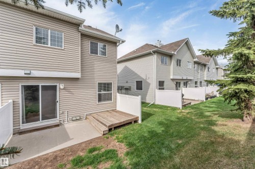 Rear exterior featuring horizontal siding, a sliding glass patio door, and a ground-level concrete patio - 135 150 Edwards Drive, Edmonton, AB - Outdoor With Exterior