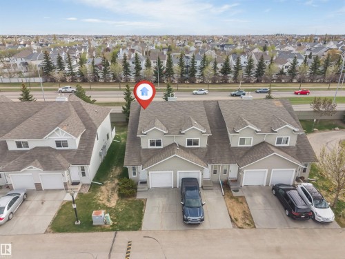 Attached townhome with a light-colored exterior and dark shingle roofing - 135 150 Edwards Drive, Edmonton, AB - Outdoor