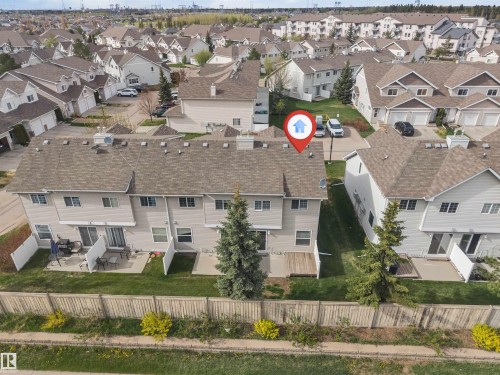 Townhouse featuring a neutral-toned exterior, gabled roofline with asphalt shingles, and multiple windows - 135 150 Edwards Drive, Edmonton, AB - Outdoor