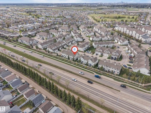 Townhome community featuring multiple buildings with attached garages and paved parking areas - 135 150 Edwards Drive, Edmonton, AB - Outdoor With View