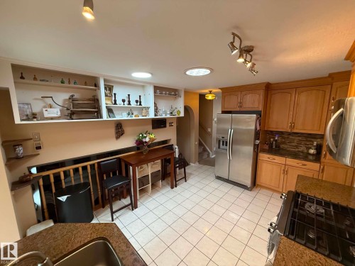 Kitchen featuring light wood cabinetry and granite-finish countertops - 2812 35 Street, Edmonton, AB - Indoor Photo Showing Kitchen