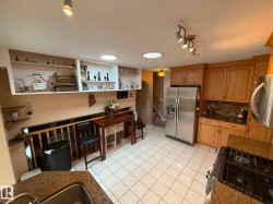 Kitchen featuring light wood cabinetry and granite-finish countertops - 