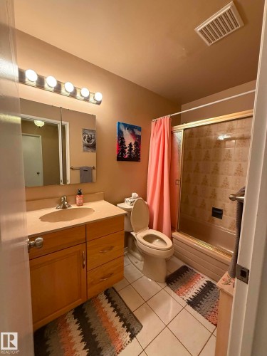 Bathroom featuring a light wood vanity with a single sink and a neutral-toned countertop - 2812 35 Street, Edmonton, AB - Indoor Photo Showing Bathroom