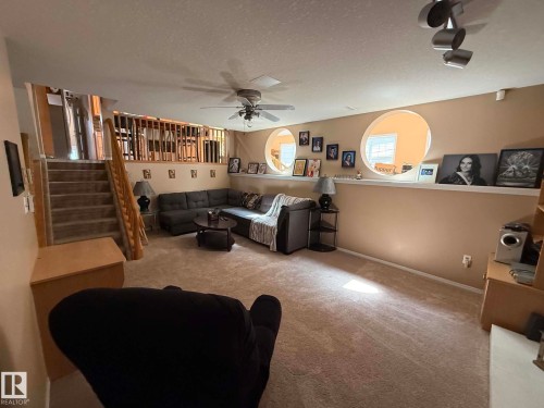 Carpeted recreation room featuring circular wall cutouts, a built-in wall shelf, recessed lighting, and a ceiling fan - 2812 35 Street, Edmonton, AB - Indoor Photo Showing Other Room