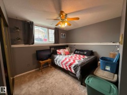 Carpeted room featuring a ceiling fan with light fixture, a window with white trim, and a white baseboard - 