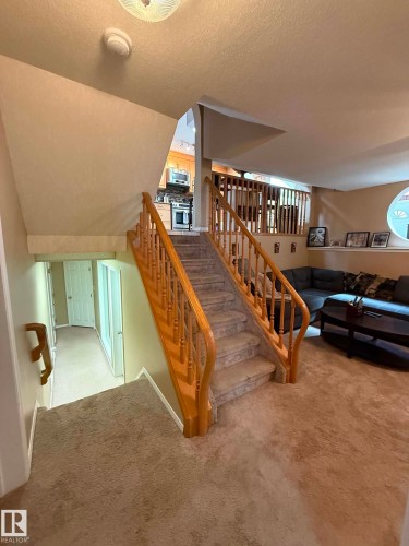 Carpeted stairway with light wood banisters and railings - 2812 35 Street, Edmonton, AB - Indoor Photo Showing Other Room