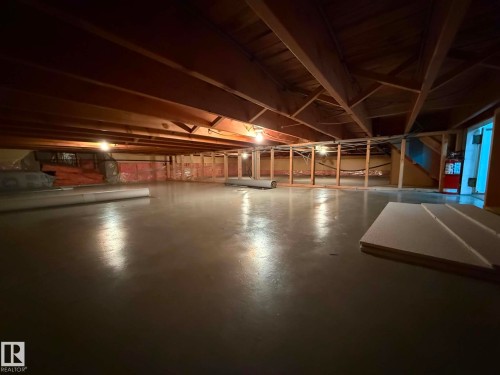Expansive unfinished basement featuring exposed wood joists and a painted concrete floor - 2812 35 Street, Edmonton, AB - Indoor