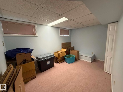 Finished room featuring a drop ceiling, flush lighting, and two windows with blinds - 2812 35 Street, Edmonton, AB - Indoor Photo Showing Basement