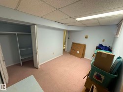 Light blue painted room with pink carpeting and a drop ceiling - 