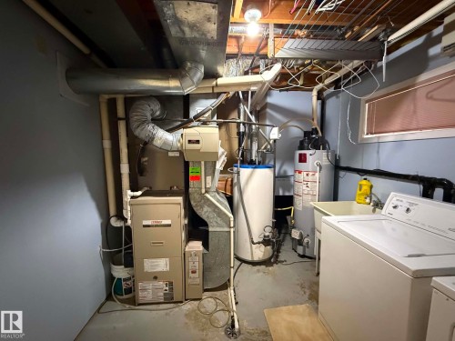 Utility room featuring a washer, dryer, laundry sink, water heater, and furnace - 2812 35 Street, Edmonton, AB - Indoor