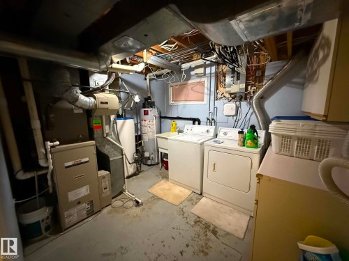 Dedicated utility room featuring a forced-air furnace, water heater, and an exposed ceiling with ductwork - 2812 35 Street, Edmonton, AB - Indoor Photo Showing Laundry Room