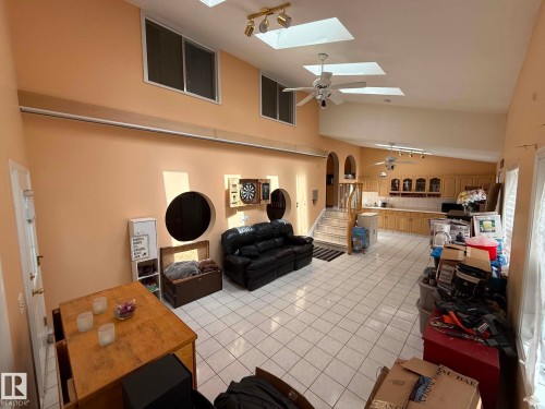 Spacious open-concept interior featuring tiled flooring, multiple skylights, and ceiling fans - 2812 35 Street, Edmonton, AB - Indoor Photo Showing Other Room