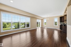 Open-concept living space featuring wood-finish flooring, recessed lighting, and a neutral color palette - 