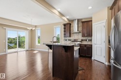 Open concept kitchen and dining area with wood-finish flooring - 