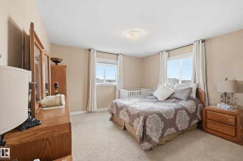 Carpeted room featuring two windows with white blinds and drapes, light tan walls, and a ceiling-mounted light fixture - 1590 Chapman Way, Edmonton, AB 