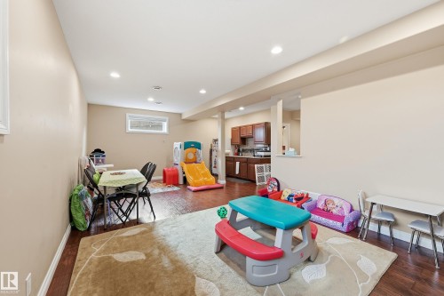 Spacious lower level featuring wood-finish flooring, recessed lighting, and a neutral wall palette - 1590 Chapman Way, Edmonton, AB 