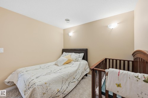 Neutral-toned room featuring a textured ceiling, recessed lighting, and wall-mounted sconces providing ambient illumination - 1590 Chapman Way, Edmonton, AB 