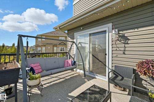 Concrete patio with dark railing, siding, and a sliding glass door - 1590 Chapman Way, Edmonton, AB 