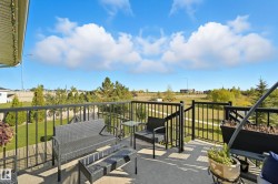 Outdoor balcony featuring concrete flooring, black metal railings, and a partially covered overhang - 