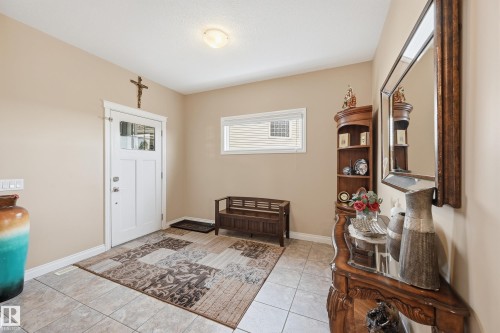 Entryway featuring tile flooring, white trim, and a transom window above the front door - 1590 Chapman Way, Edmonton, AB 