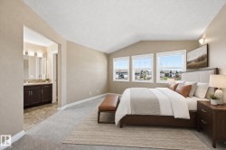 Spacious bedroom featuring an vaulted ceiling, three large windows, and soft gray carpeting - 