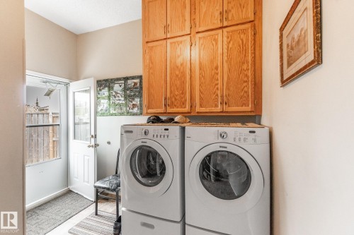 Utility area featuring wood cabinetry, light-toned walls, and a glass-paneled exterior door - 4611 Lakeshore Drive, Bonnyville Town, AB - Indoor Photo Showing Laundry Room