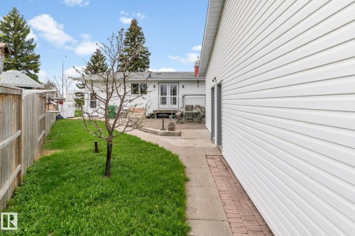 Detached garage with white vinyl siding, featuring a concrete pathway leading to a brick patio - 4611 Lakeshore Drive, Bonnyville Town, AB - Outdoor