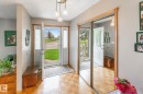 Foyer featuring wood-finish flooring, a decorative chandelier, a mirrored sliding door, and a front entry door with glass sidelights - 4611 Lakeshore Drive, Bonnyville Town, AB  - Indoor Photo Showing Other Room 
