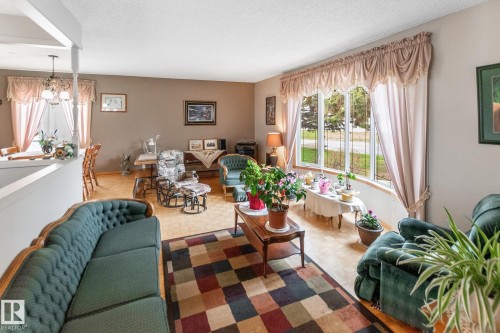 Spacious living area featuring wood-finish flooring, neutral wall paint, and a large bay window - 4611 Lakeshore Drive, Bonnyville Town, AB - Indoor Photo Showing Living Room
