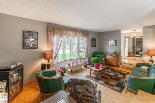 Living area featuring a wide bay window and wood-finish flooring - 4611 Lakeshore Drive, Bonnyville Town, AB - Indoor Photo Showing Living Room