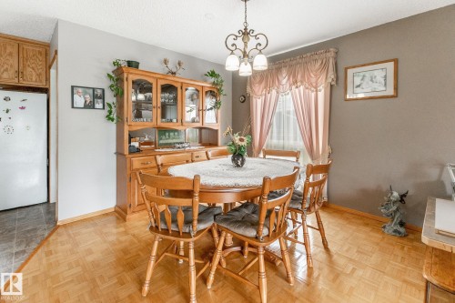 Dining area featuring parquet wood flooring and a decorative chandelier - 4611 Lakeshore Drive, Bonnyville Town, AB - Indoor Photo Showing Dining Room