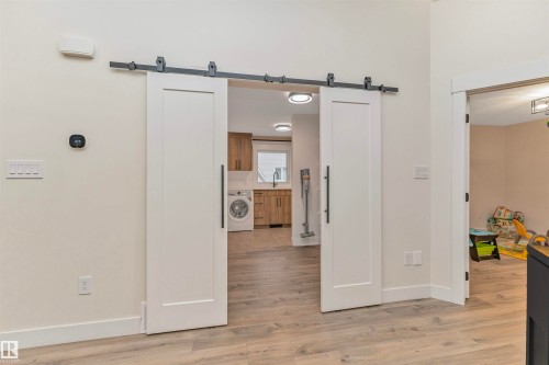 Dual white barn doors with matte black hardware - 627 Forest Lane, Edmonton, AB - Indoor Photo Showing Other Room