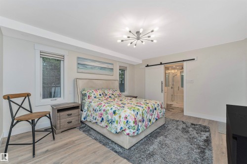 Bedroom featuring light wood-finish flooring, recessed lighting, and an overhead sputnik chandelier - 627 Forest Lane, Edmonton, AB - Indoor Photo Showing Bedroom