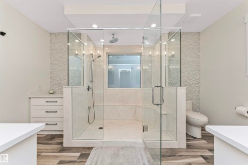 Spacious shower enclosure with glass panels, dual shower heads, and built-in bench seating - 627 Forest Lane, Edmonton, AB - Indoor Photo Showing Bathroom