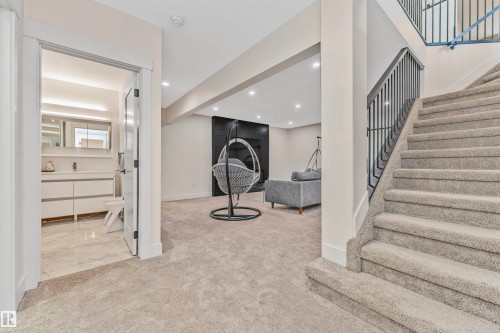 Plush carpeted staircase with a dark metal railing - 627 Forest Lane, Edmonton, AB - Indoor Photo Showing Other Room