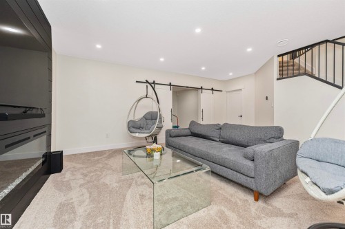 Carpeted room featuring a dark wood-paneled entertainment wall, recessed lighting, and white baseboards - 627 Forest Lane, Edmonton, AB - Indoor Photo Showing Living Room