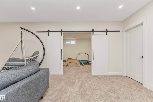 Carpeted room featuring recessed lighting and a pair of white barn doors on a black track - 627 Forest Lane, Edmonton, AB - Indoor