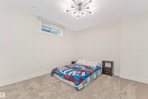 Carpeted room featuring a single window, white walls, and a modern sputnik-style ceiling light fixture - 627 Forest Lane, Edmonton, AB - Indoor Photo Showing Bedroom