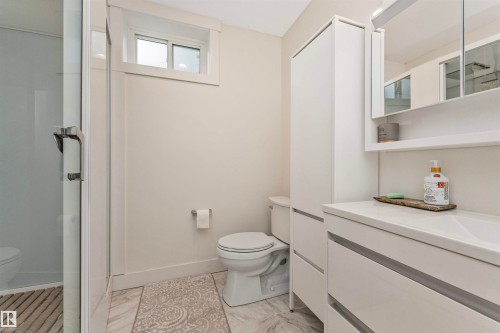 Contemporary bathroom with a glass-enclosed shower, white tile flooring, and a sliding window - 627 Forest Lane, Edmonton, AB - Indoor Photo Showing Bathroom