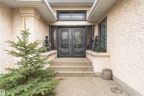 Architectural entrance featuring double black doors with decorative glass panels, a transom window with grille, and flanking sidelights - 627 Forest Lane, Edmonton, AB - Outdoor