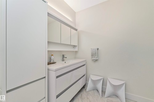 Modern bathroom featuring a single vanity with integrated sink, chrome faucet, and under-cabinet lighting - 627 Forest Lane, Edmonton, AB - Indoor