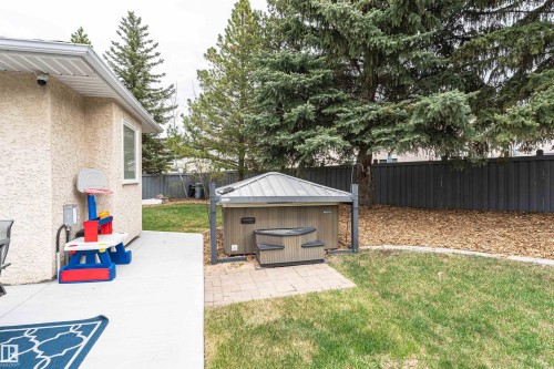 Backyard featuring a hot tub on a paver patio with an adjacent concrete patio - 627 Forest Lane, Edmonton, AB - Outdoor