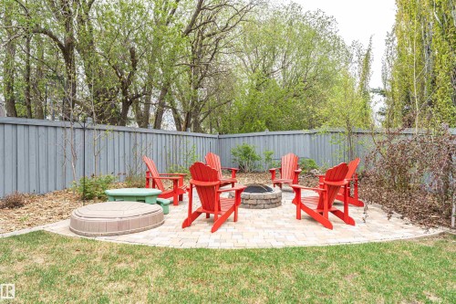 Landscaped backyard featuring a paver patio with a built-in stone fire pit - 627 Forest Lane, Edmonton, AB - Outdoor With Deck Patio Veranda With Backyard