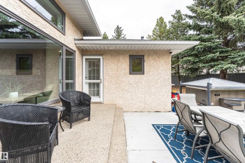 Exterior patio featuring stucco siding, large windows, and an outdoor spa - 627 Forest Lane, Edmonton, AB - Outdoor With Exterior