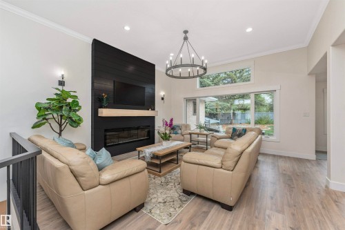 Living area with a contemporary linear electric fireplace and a black shiplap accent wall - 627 Forest Lane, Edmonton, AB - Indoor Photo Showing Living Room With Fireplace